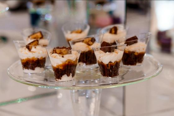 Layered dessert cups served on a glass stand