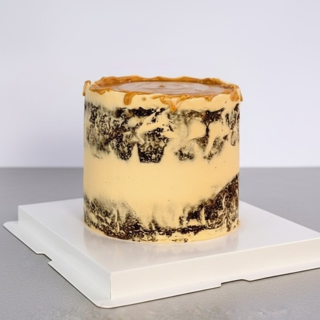 The same cake from the side, showing the semi-naked finish and the caramel drizzle running over the edge